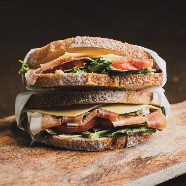 Sandwiches hechos con rodajas de pan casero con tomate, lechuga, fetas de queso y jamón crudo